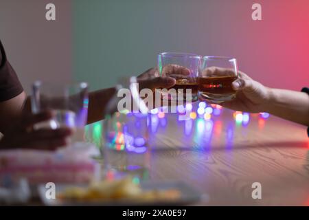 Un gruppo di uomini d'affari ha tenuto insieme gli occhiali di brandy per applaudire gli occhiali di brandy dopo aver concluso le trattative sulle imprese e aver raggiunto un sati Foto Stock