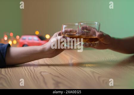 Un gruppo di uomini d'affari ha tenuto insieme gli occhiali di brandy per applaudire gli occhiali di brandy dopo aver concluso le trattative sulle imprese e aver raggiunto un sati Foto Stock