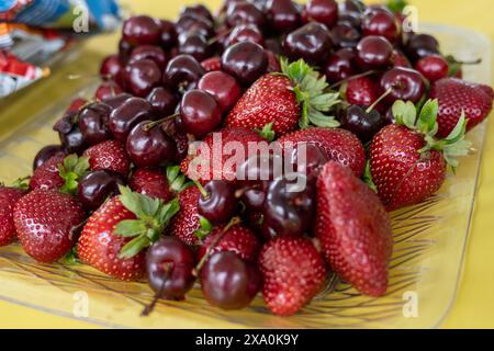 Il piatto di fragole e ciliegie viene lavato e pronto per essere mangiato dagli ospiti. Foto Stock