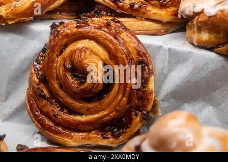 Pain au uvetta, panini dolci francesi con impasto sfogliato con uvetta, panini di caffè in forno Foto Stock