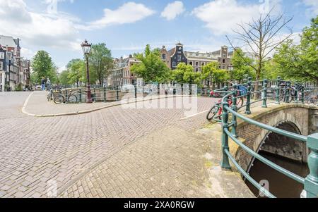 Biciclette appoggiate alle ringhiere lungo parte dei canali Keizersgracht e Reguliersgracht ad Amsterdam, Paesi Bassi visti il 28 maggio 2024. Foto Stock