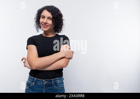 Donna bruna adulta con capelli ricci e una maglietta nera Foto Stock