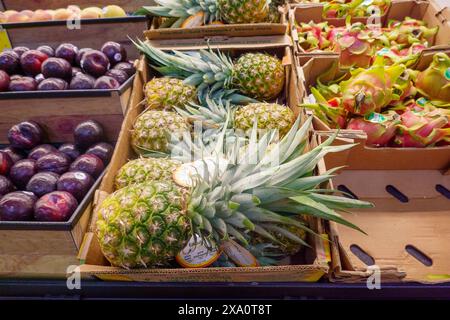 Ananas interi freschi in vendita nella sezione prodotti da supermercato Foto Stock