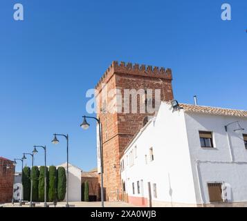 Un'alta torre di mattoni si erge orgogliosa, è la torre di juan d'austria che sorge nell'Alcazar de san Juan in un giorno d'estate blu. Foto Stock
