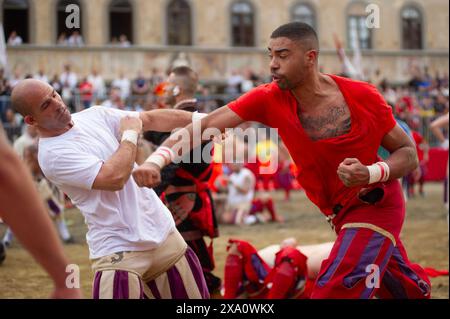 I giocatori si scontrano durante la semifinale tra le squadre bianche (Santo Spirito) e rosse (Santa Maria Novella) del calcio storico Fiorentino a Firenze (Italia), piazza Santa Croce, 1 giugno 2024. Il calcio storico Fiorentino, noto anche come calcio in costume, è un gioco di squadra con un pallone dalle origini remote e oggi una delle più antiche tradizioni fiorentine. Il gioco è una sfida tra i quattro quartieri della città. Le partite si giocano in costumi del XVI secolo e ogni anno viene organizzato un torneo che coinvolge i quattro quartieri storici della città Foto Stock