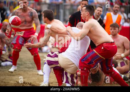 I giocatori si scontrano durante la semifinale tra le squadre bianche (Santo Spirito) e rosse (Santa Maria Novella) del calcio storico Fiorentino a Firenze (Italia), piazza Santa Croce, 1 giugno 2024. Il calcio storico Fiorentino, noto anche come calcio in costume, è un gioco di squadra con un pallone dalle origini remote e oggi una delle più antiche tradizioni fiorentine. Il gioco è una sfida tra i quattro quartieri della città. Le partite si giocano in costumi del XVI secolo e ogni anno viene organizzato un torneo che coinvolge i quattro quartieri storici della città Foto Stock