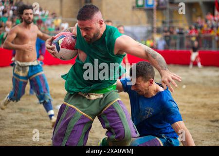 I giocatori si scontrano durante la semifinale tra le squadre Blues (Santa Croce) e Greens (San Giovanni - Duomo) del calcio storico Fiorentino di Firenze (Italia), piazza Santa Croce, 1 giugno 2024. Il calcio storico Fiorentino, noto anche come calcio in costume, è un gioco di squadra con un pallone dalle origini remote e oggi una delle più antiche tradizioni fiorentine. Il gioco è una sfida tra i quattro quartieri della città. Le partite si giocano in costumi del XVI secolo e ogni anno viene organizzato un torneo che coinvolge i quattro quartieri storici della città Foto Stock
