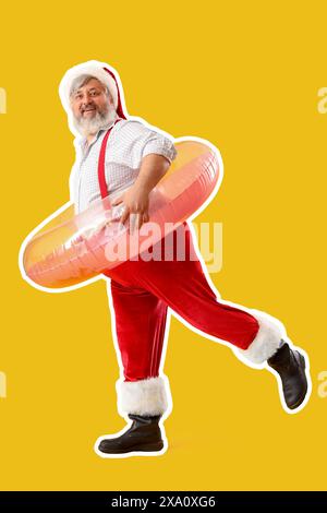 Babbo Natale con anello gonfiabile su sfondo giallo. Natale a luglio Foto Stock