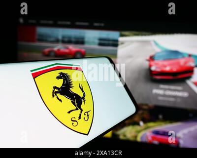 Smartphone con logo della casa automobilistica italiana Ferrari Spa di fronte al sito Web aziendale. Messa a fuoco al centro del display del telefono. Foto Stock