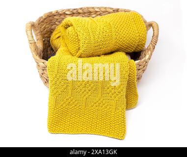 una foto di una coperta a maglia gialla con motivo a diamante in un cestello isolato su uno sfondo bianco Foto Stock