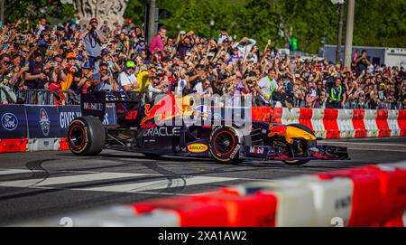 Un'auto da corsa rossa catturata con il pubblico in sottofondo Foto Stock