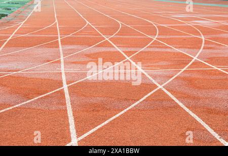 La pista rossa brillante intreccia la traiettoria bianca diritta con la traiettoria bianca curva. Foto Stock