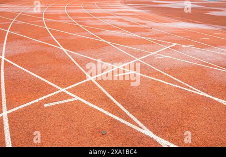 La pista rossa brillante intreccia la traiettoria bianca diritta con la traiettoria bianca curva. Foto Stock