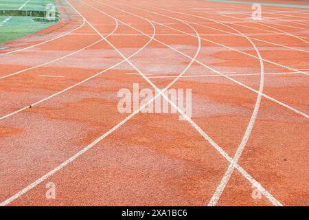 La pista rossa brillante intreccia la traiettoria bianca diritta con la traiettoria bianca curva. Foto Stock