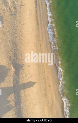 onde di un mare verde turchese sulla riva della costa all'alba, vista spettacolare con drone Foto Stock