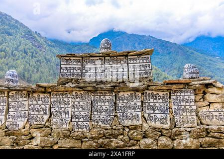 Mani di pietre sacre del Nepal con mantra scritto e scolpito sulla superficie. Pietre di preghiera shire sul sentiero di trekking di montagna sull'Everest base Camp Trek Foto Stock