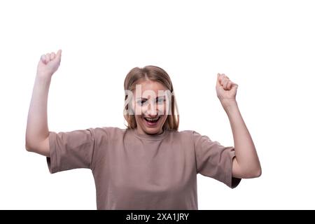 Ritratto di una donna bionda caucasica divertente in una maglietta con grimaci sul viso Foto Stock