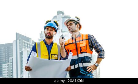 I due uomini che esaminano i progetti per i materiali da costruzione su un tetto. Foto Stock