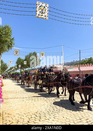 La Fiera di Siviglia nota come Fiera de Abril si tiene a Siviglia, Andalusia per una settimana. Le donne vestono con abiti flamenco e gli uomini con abiti eleganti Foto Stock