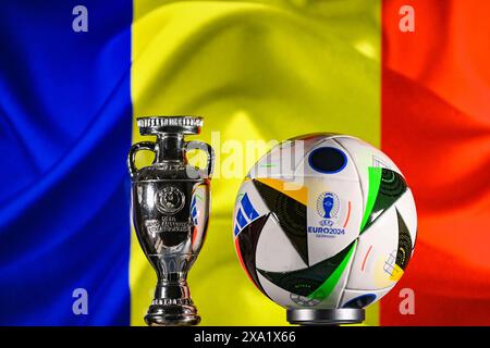 1° giugno 2024, Berlino, Germania. Il pallone ufficiale di Euro 2024 Adidas Fussballliebe e la Coppa dei campioni sullo sfondo della bandiera della Romania. Foto Stock