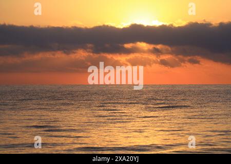 Il tramonto sull'oceano sereno Foto Stock