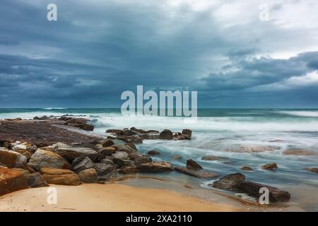 The Rocks on shore si è riversata in acqua prima della tempesta Foto Stock