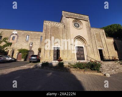 Una chiesa non occupata circondata da un parcheggio e da una strada piena di veicoli fissi Foto Stock