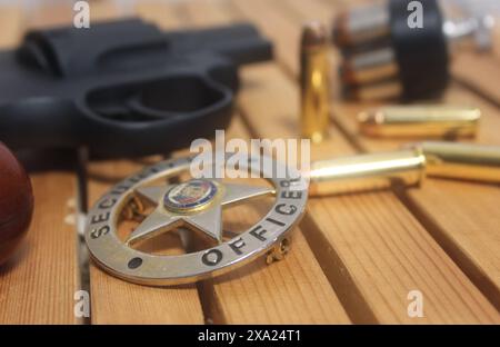 Un distintivo della guardia di sicurezza con una pistola e proiettili Foto Stock