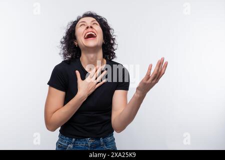 Ritratto di una donna che ride a voce alta con un perm che indossa una T-shirt di base Foto Stock
