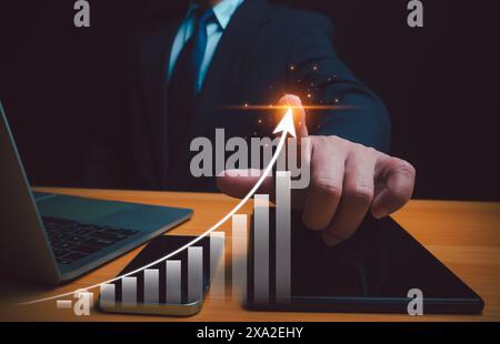 Uomo d'affari che punta il grafico a freccia del piano di crescita futura aziendale, il concetto di sviluppo aziendale verso il successo e la crescita in crescita, fissando obiettivi per il business Foto Stock