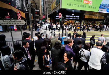 Pedoni che attraversano Queen's Road Central a Hong Kong. Foto Stock