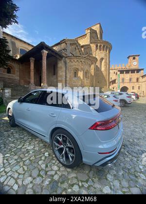 Cremona, Italia - 2 maggio 2024, in mostra il contrasto tra l'ingegneria moderna e l'architettura antica, un'auto elegante si trova parcheggiata sul ciottolo Foto Stock