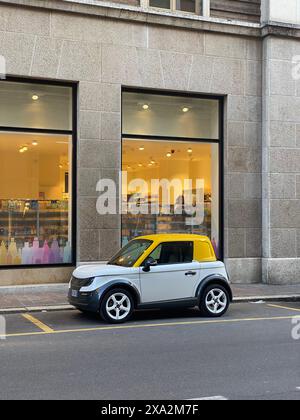 Cremona, Italia - 2 maggio 2024 piccola ed elegante auto elettrica Tazzari italiana parcheggiata su una strada in un ambiente urbano, incarnando la moderna trasposizione Foto Stock