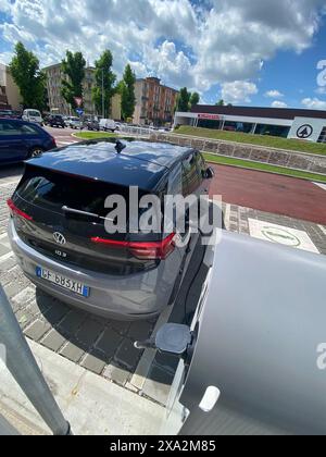 Cremona, Italia - 2 maggio 2024 le moderne auto elettriche si caricano su una strada cittadina, mostrando l'ascesa dei trasporti urbani ecologici. Questa immagine viene acquisita Foto Stock