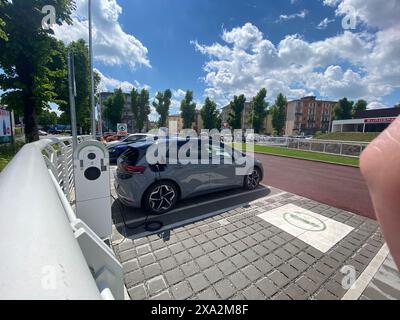 Cremona, Italia - 2 maggio 2024 approfittando dei vantaggi della guida di un'auto elettrica, un conducente si collega a una stazione di ricarica. La stazione di ricarica è Foto Stock