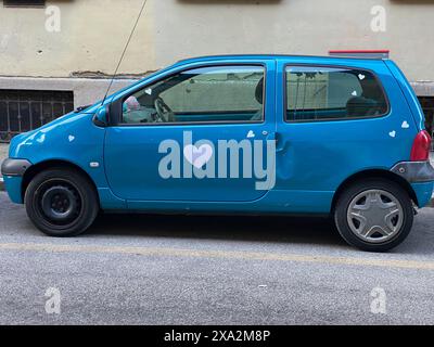 Cremona, Italia - 2 maggio 2024 esprimendo affetto con un tocco di fantasia, un'auto blu renault twingo adornata di cuori bianchi diventa simbolo di lov Foto Stock