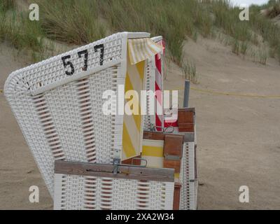 Vista laterale di una sdraio con il numero 577 sulla spiaggia sabbiosa vicino alle dune, Baltrum Germania Foto Stock