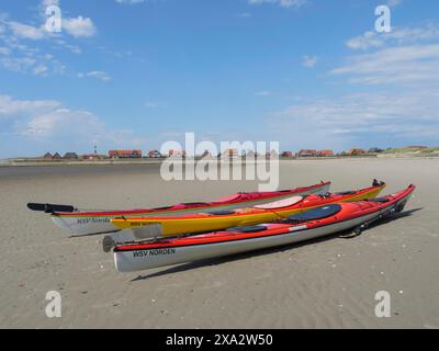 Kayak sulla spiaggia con villaggio sullo sfondo, Baltrum Germania Foto Stock