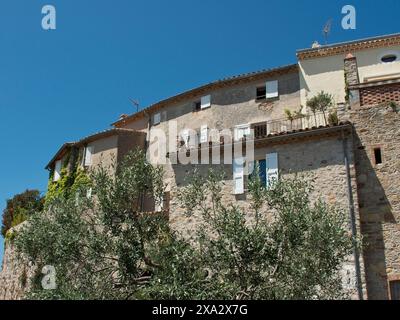 Case rustiche in pietra con persiane bianche e vegetazione contro un cielo azzurro, Provence, le Castellet, Francia Foto Stock