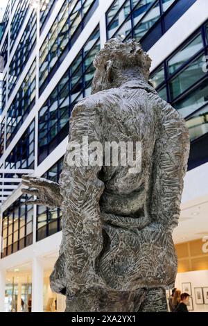 La vista posteriore di una scultura in bronzo al centro di un moderno edificio in vetro, Willy-Brandt-Haus, sede SPD, Berlino, Berlino, Germania Foto Stock