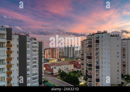 Paesaggio urbano di Antalya al tramonto con condomini in primo piano e montagne sullo sfondo Foto Stock