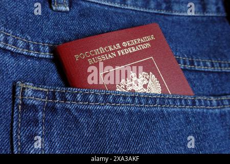 Passaporto straniero rosso della Federazione Russa nella tasca posteriore dei jeans blu foto ravvicinata Foto Stock