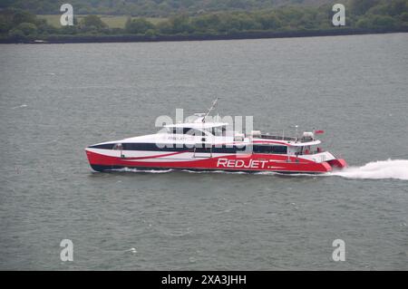 Traghetto passeggeri Red Funnel Hi-Speed Catamaran 'Red Jet 6' in navigazione sul Solent a Southampton dall'Isola di Wight, Hampshire, Inghilterra, Regno Unito. Foto Stock