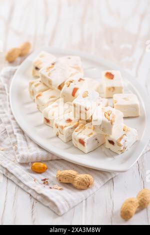 Torrone morbido con arachidi su un piatto, dolci gommosi con noci Foto Stock