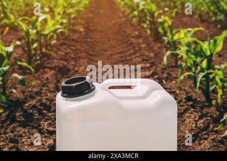 Primo piano del contenitore di erbicidi nel campo del mais, messa a fuoco selettiva Foto Stock