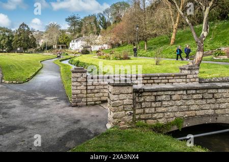 Una piccola passerella sul fiume che scorre attraverso gli storici e premiati Trenance Gardens a Newquay in Cornovaglia nel Regno Unito. Foto Stock