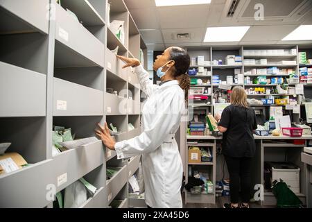 Farmacisti che lavorano in una stanza di deposito dei farmaci in uno studio medico, Regno Unito Foto Stock