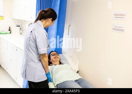 Infermiera che si occupa di un paziente in una clinica Foto Stock