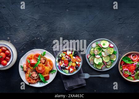 Insalate fresche, posate a soffitto di un assortimento. Varietà di piatti e ciotole con verdure verdi. Cibo sano, top shot, con spazio di copia Foto Stock