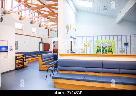 Moderna area d'attesa con comodi posti a sedere e display informativi in un ospedale, Regno Unito. Foto Stock